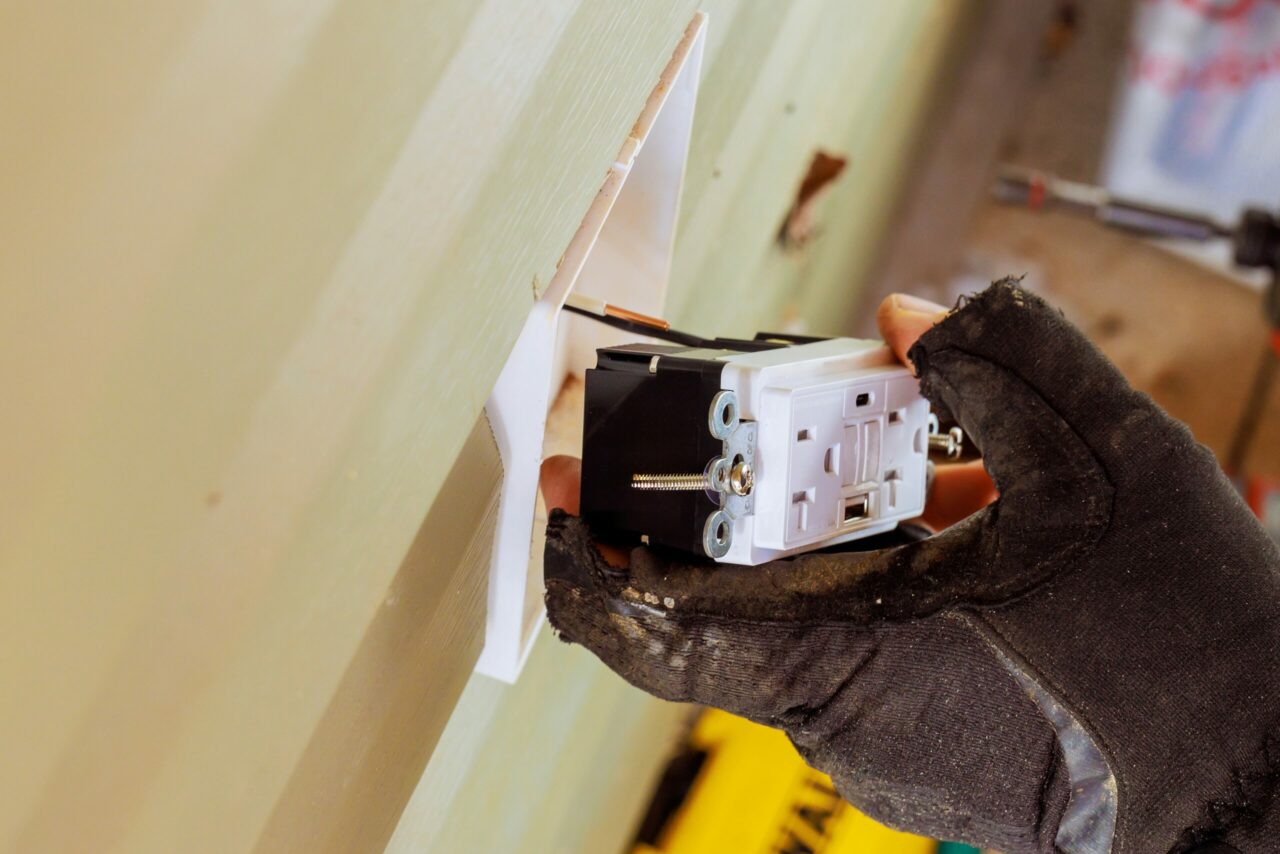 Electrician Wiring a GFCI Outlet During Installation