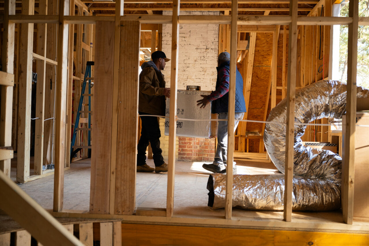 Tradesmen carrying an HVAC unit during installation
