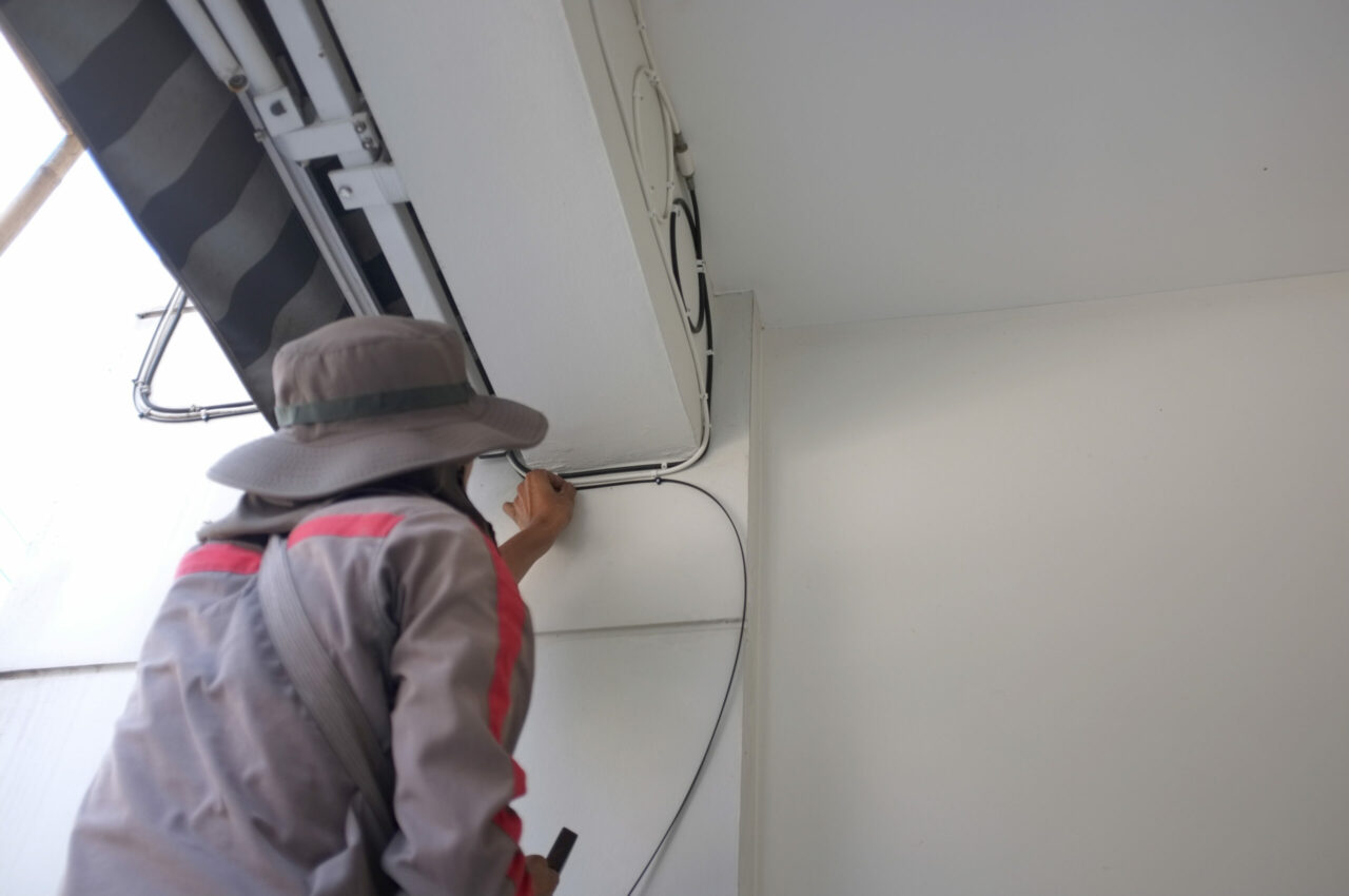 Construction Site Electrician. Worker with Electric Cables.