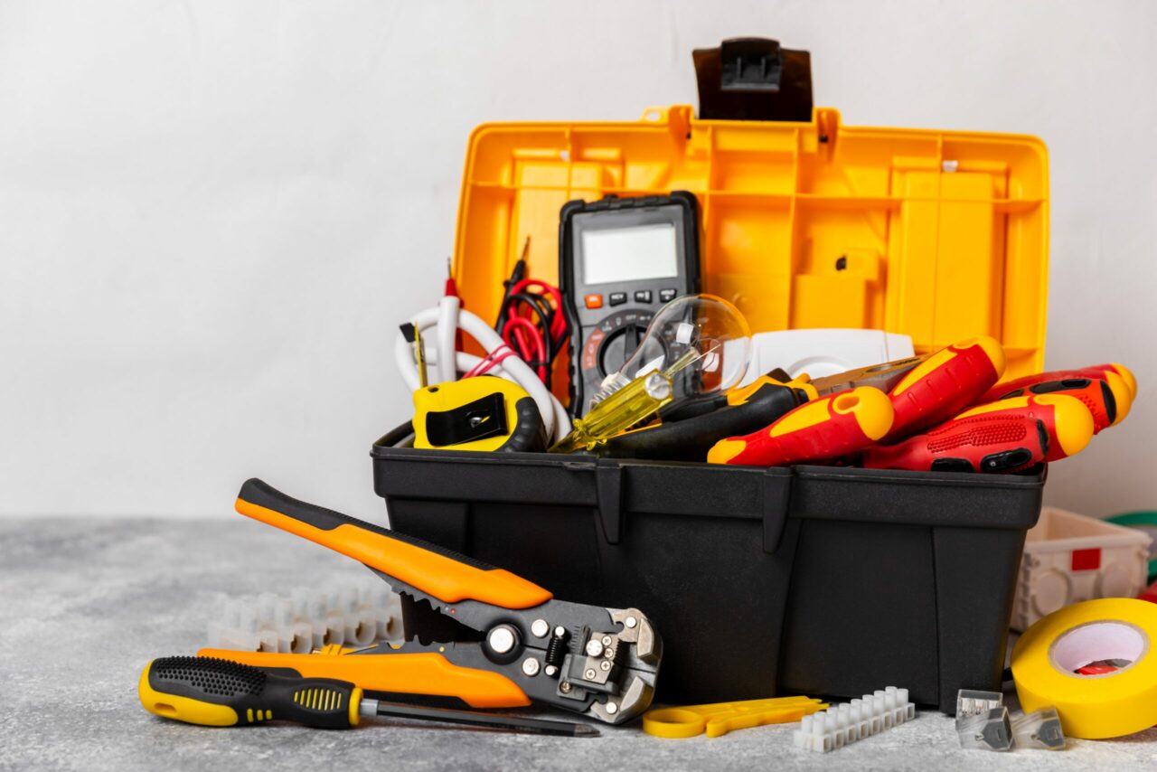 Electrician equipment on marble background with copy space.Top view.Electrician tool set.Multimeter, tester,screwdrivers,cutters,duct tape,lamps,tape measure and wires