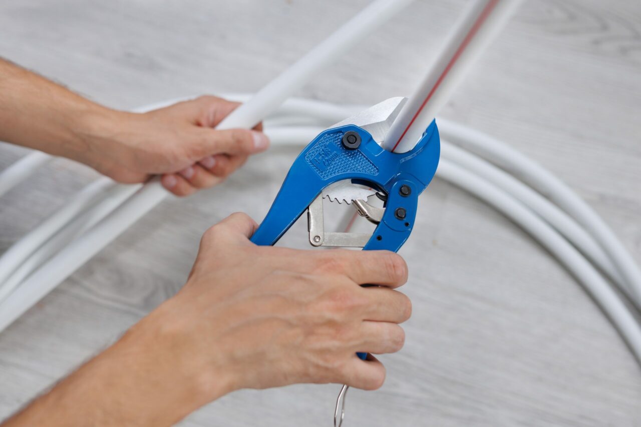 Technician cutting pipe clean and square with tubing cutter tool