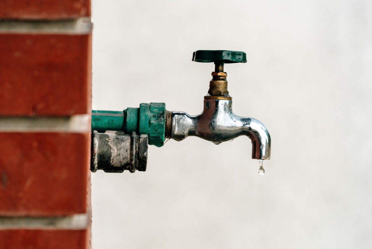 back yard outdoor garden faucet with drops of water