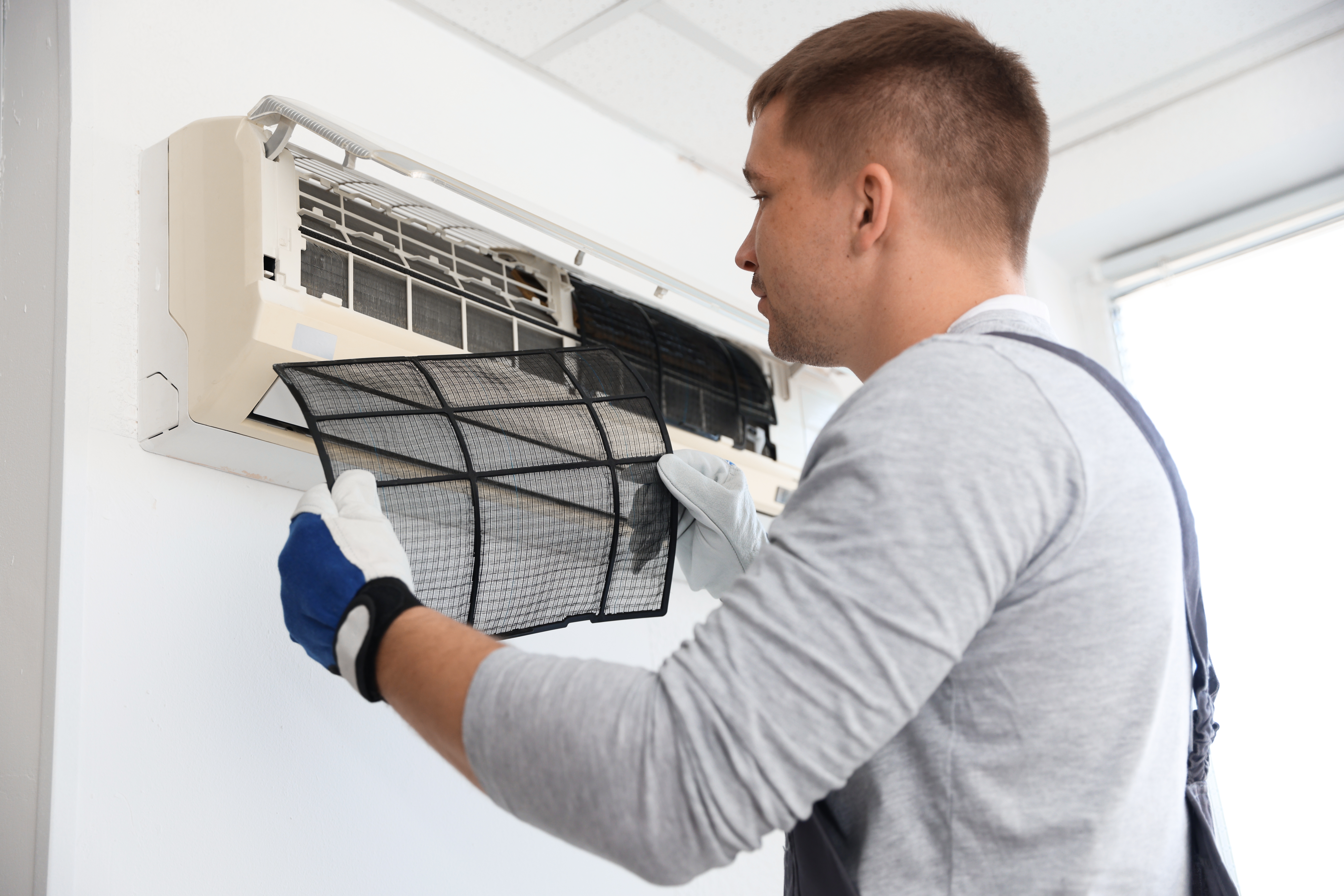 Professional technician cleaning air conditioner