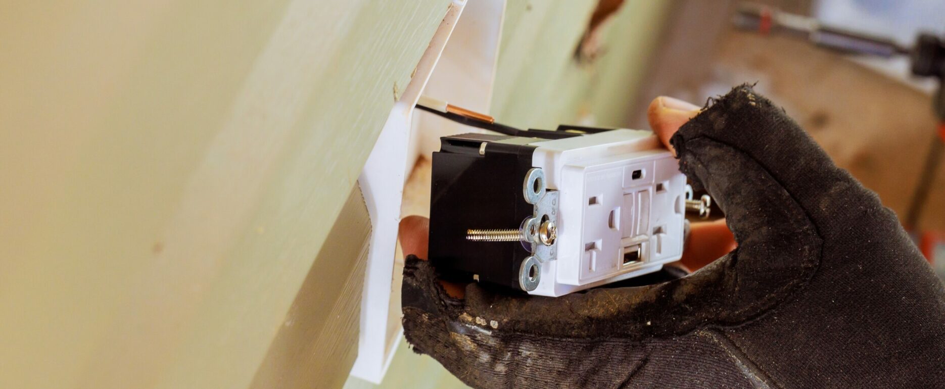 Electrician Wiring a GFCI Outlet During Installation