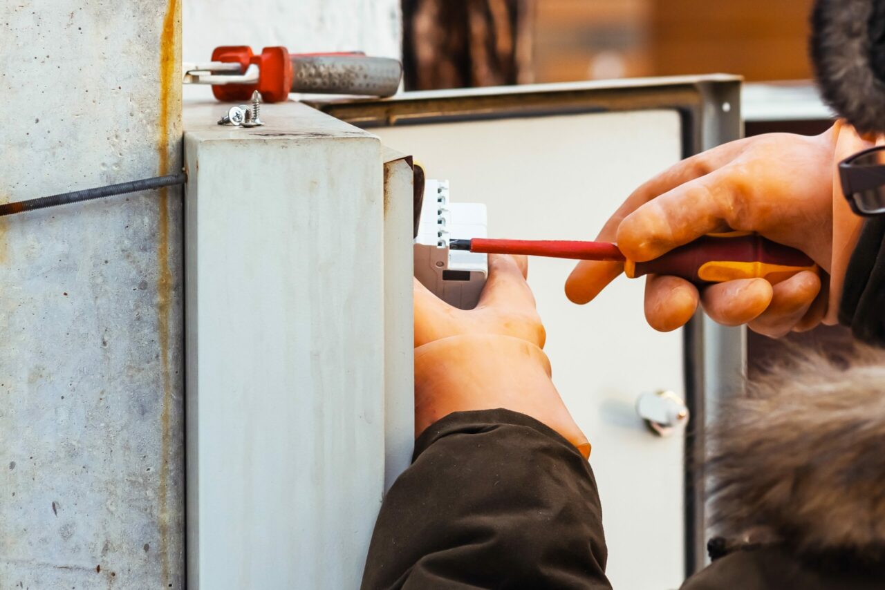 An electrician changes a circuit breaker in an electrical panel