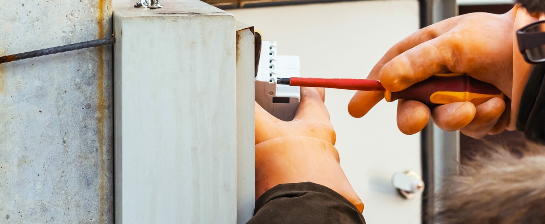 An electrician changes a circuit breaker in an electrical panel