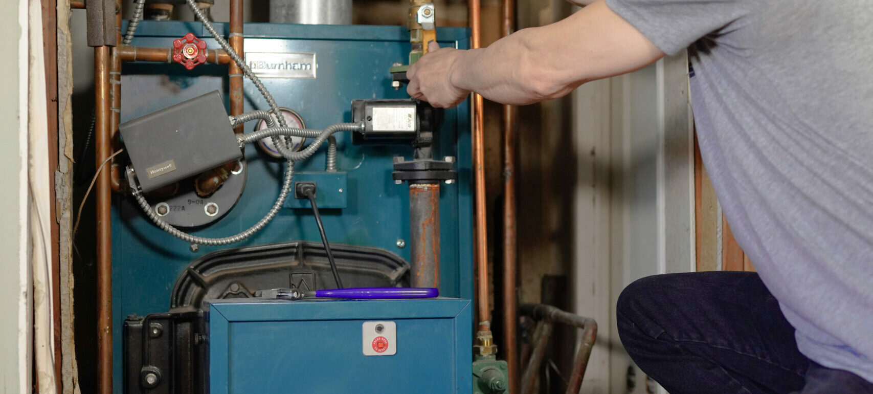 TM tightening a ball valve on a line during a boiler installation