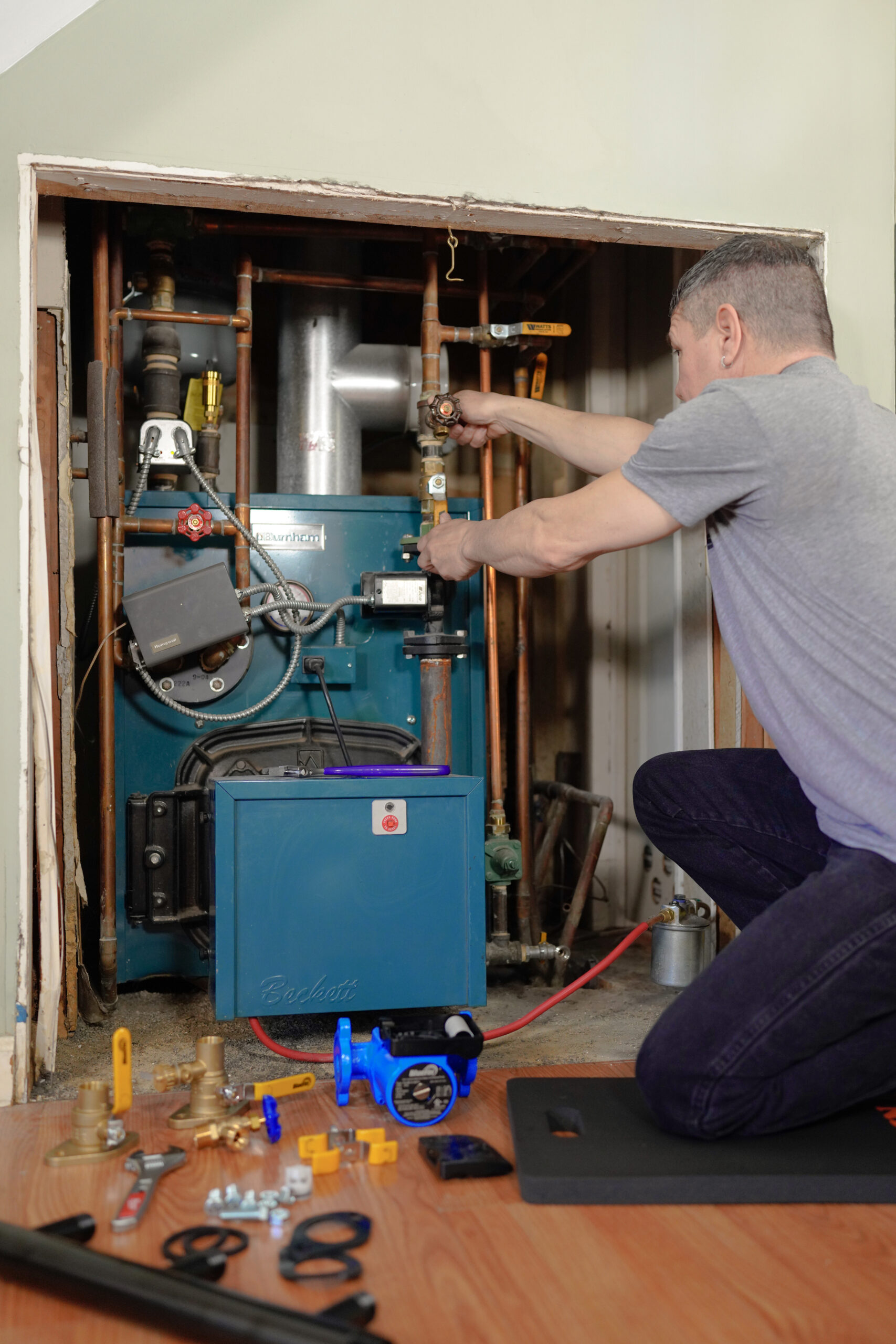 TM tightening a ball valve on a line during a boiler installation