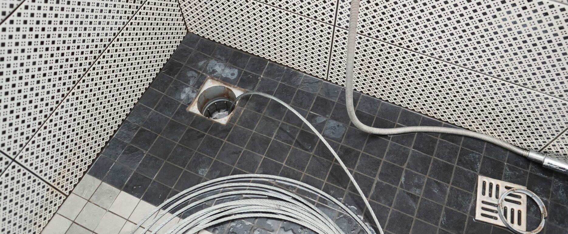 Cleaning the sewer with a snake to unclog the shower