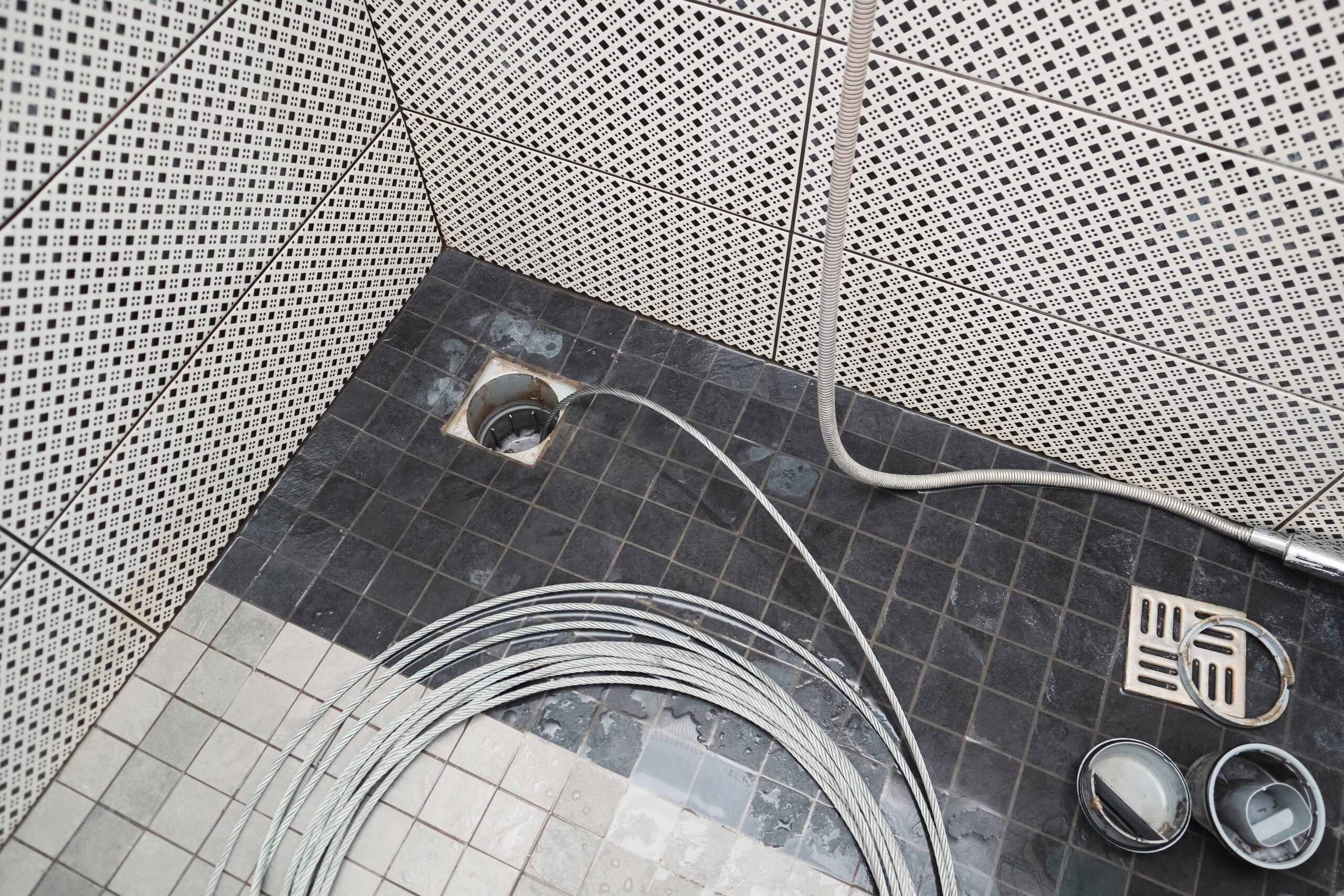 Cleaning the sewer with a snake to unclog the shower