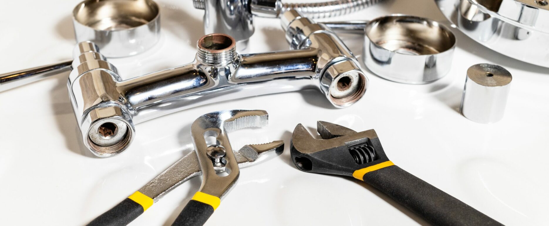 shower faucet details and adjustable wrenches on white ceramic shower tray