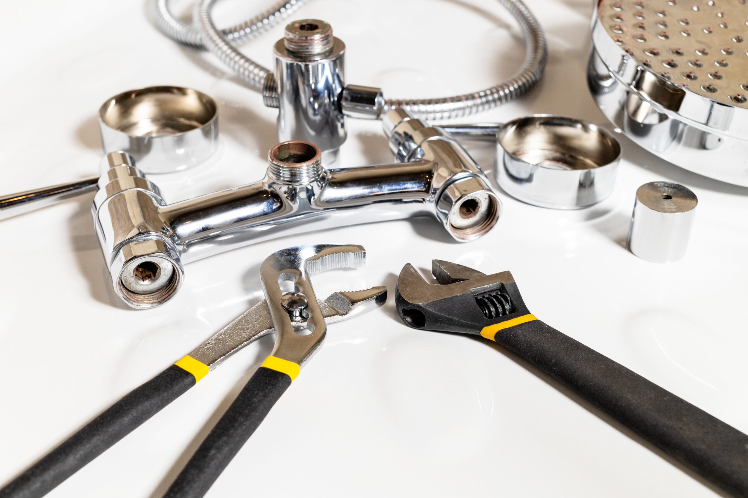 shower faucet details and adjustable wrenches on white ceramic shower tray