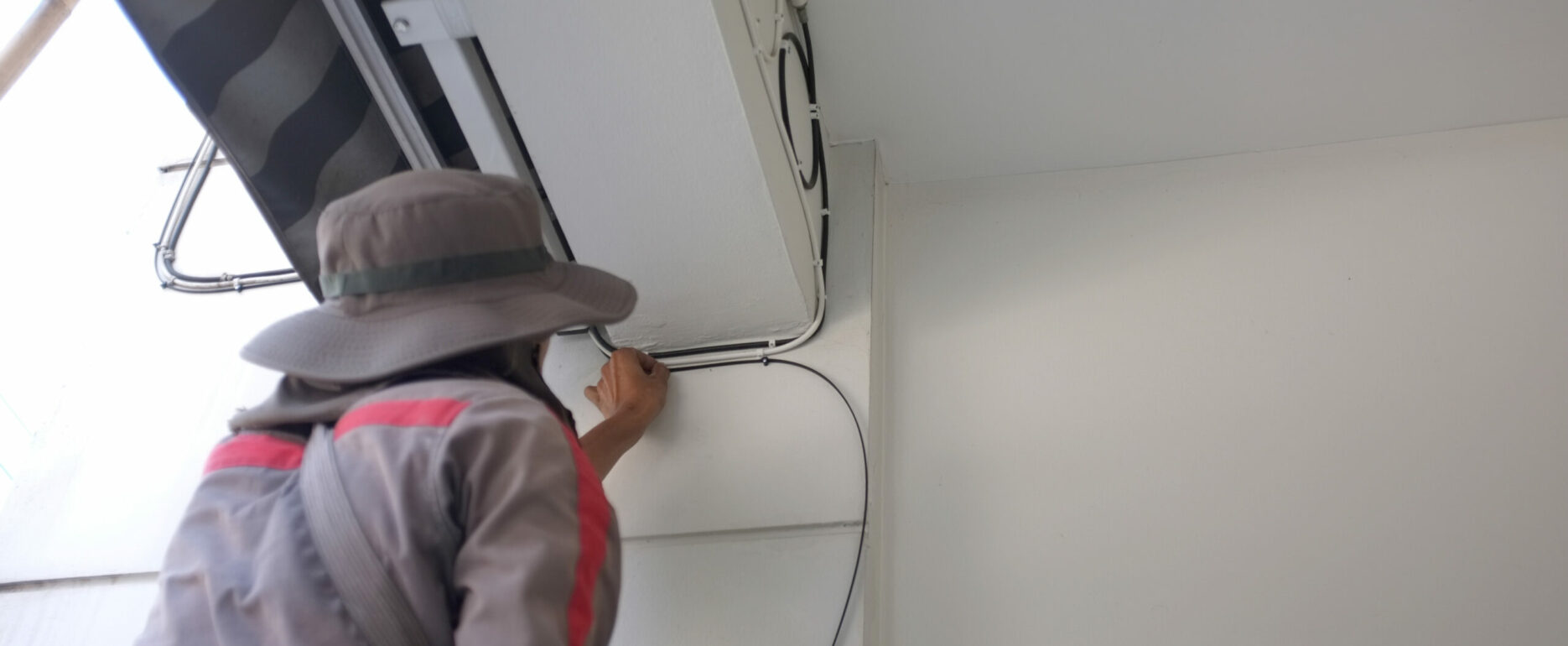 Construction Site Electrician. Worker with Electric Cables.