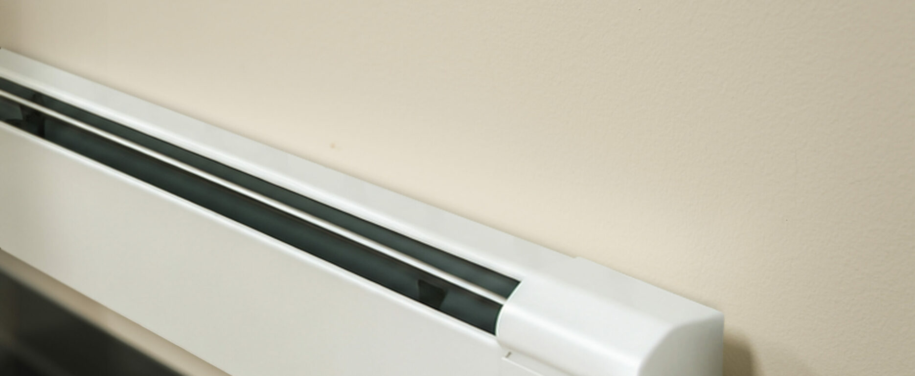 Fin-Tube Baseboard Heater Installed Along a Finished Wall.